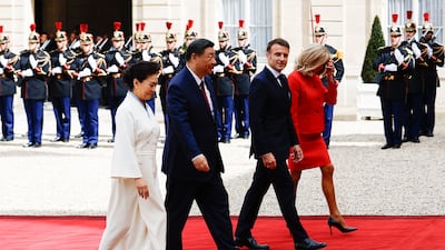 Mr Xi, Ms Peng, Mr Macron and Ms Macron walk past an honour guard to the palace. EPA