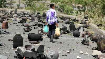 A boy walks on a street littered with cooking gas cylinders after a fire and explosions destroyed a nearby storage space during clashes between pro-government forces and Houthi fighters in Taez on July 19. Reuters