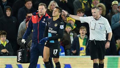Arsenal's Alexis Sanchez, centre, was first pushed into a pit on the sidelines and then tripped to pull his right hamstring against Norwich City. Michael Regan / Getty Images