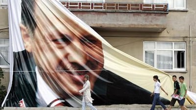 People walk past a giant poster of Recep Tayyip Erdogan, the Turkish prime minister, in Sakarya, Turkey. Saygin Serdaroglu / AFP