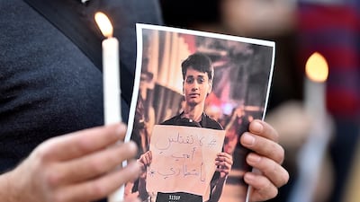 A Lebanese activist carries a candle and a picture for an Iraqi child who died during the uprising in Iraq during a gathering to support the children in the uprising in Iraq in front of the Iraqi embassy in Beirut. EPA