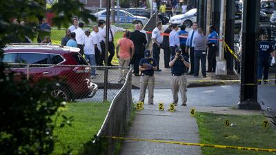 New York police department crime scene investigators photograph evidence on Saturday, Aug. 13, 2016, in the Queens borough of New York, after the leader of a mosque and an associate were shot dead as they left afternoon prayers. AP Photo/Craig Ruttle