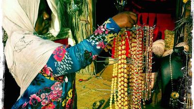Day trip with friends to the Western Region and the Mazayin Dhafra Camel Festival, 220 kms west of Abu Dhabi on December 20, 2013. A merchant organises her wares at the traditional souk. Picture taken with the Hipstamatic app for the iPhone. Liz Claus / The National