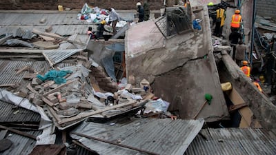 Rescue workers gather around a collapsed building in Huruma estate, Nairobi, Kenya, Sunday, June 3, 2018. Pius Masai Mwachi of the National Disaster Management Unit says a rescue operation is going on after a five-story residential building collapsed early Sunday in Nairobi's Huruma Ngei neighborhood.(AP Photo/Sayyid Abdul Azim)