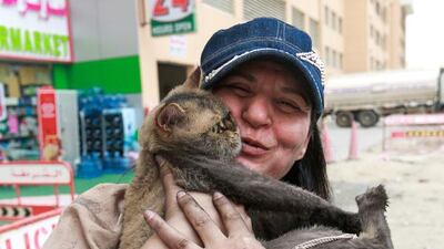 Together again – Layla Al Wawi is in tears of joy after finding her cat, Dora, under her bed days after the fire. Her other feline companion was a casualty of the Ajman One evacuation. Victor Besa for The National