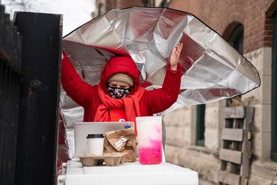 Pre-K teacher Kirstin Roberts covers herself with a warming blanket during a virtual class outside in Chicago, on January 4. AP