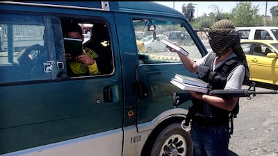 June 22, 2014: An ISIL fighter distributing a copy of the Quran to a driver in central Mosul. AP Photo