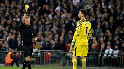 Referee Jon Moss shows a yellow card to Tottenham goalkeeper Hugo Lloris. Tim Ireland / AP Photo