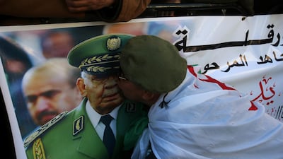 A participant kisses a picture of Lt Gen Gaid Salah. Reuters