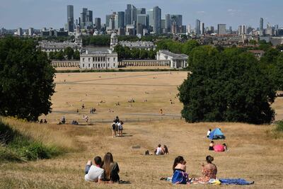People sit on sun-scorched grass in Greenwich Park, south-east London. in the summer of 2022. AFP