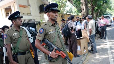 Sri Lankan police officers stand guard as polling officials prepare to leave for polling stations for the presidential election. AP Photo
