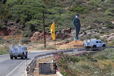 UN peacekeeping vehicles pass a Hezbollah flag and a statue of the late Iranian General Qassem Soleimani, as they patrol on a road along the Lebanese-Israeli border town of Naqoura. AP