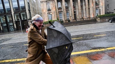 Strong winds threaten to blow away an umbrella in Edinburgh. Reuters