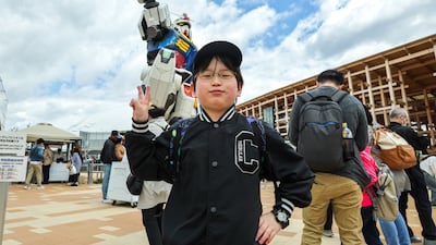 Reo Okuhira, 9, poses in front of the Gundam robot
