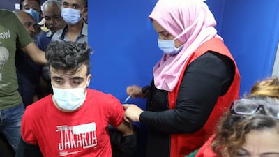 A man receives a dose of the vaccine against Covid-19 as others queue at the Sadat underground station, Cairo. EPA