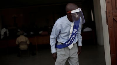 A parishioner, using a face shield, looks on at an entrance of the cathedral during a mass on the first day of the reopening of places of worship amid the coronavirus outbreak, in Port-au-Prince, Haiti. Reuters