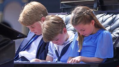 Prince George, Prince Louis and Princess Charlotte bow their heads as they receive a salute as the Royal Procession returns to Buckingham Palace after the Trooping the Colour ceremony at Horse Guards Parade, central London. PA