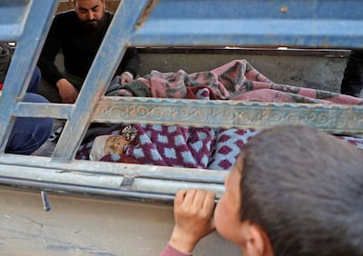 A Syrian boy looks at the body of a child during a funeral in the the village of Atareb in Aleppo on March 21, for civilians killed in regime artillery fire on a hospital. AFP