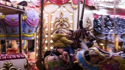 A mother and child enjoy a merry-go-round ride before the start of a new curfew in Marseille, southern France. AP Photo