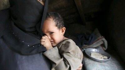 A woman holds her child in their home in Sanaa. A million Yemeni children face severe malnutrition within months as families struggle to pay for food in one of the Arab world's poorest countries.
