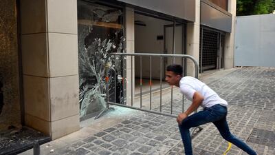 A metal barrier is used to smash windows during a protest against power cuts, the high cost of living, and the low purchasing power of the pound near the Lebanese Parliament in Beirut. EPA