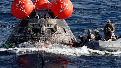 US Navy divers attach winch cables to Nasa's Orion capsule off the coast of Baja California, Mexico. EPA
