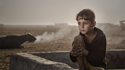 Photo by Ahmed Abdulameer Al Bumsheh taken in Iraq during a time when the villagers set a fire to get rid of all the flies and pests. The smoke in the background set the scene for the artist to take the photo. Courtesy National Geographic Abu Dhabi