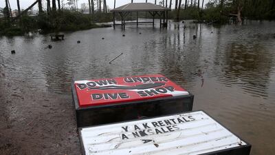 A damaged sign is pictured at a flooded lot during Hurricane Sally in Gulf Shores, Alabama. REUTERS