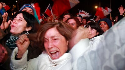 Residents cheer when the first rescuer reached the underground refuge of the miners trapped in the San Jose mine, while watching on a large screen in a public square in Copiapo October 12, 2010. Chile's 33 trapped miners are set to travel nearly half a mile through solid rock in a shaft just wider than a man's shoulders on Tuesday night, as their two month ordeal after a cave-in draws to an end. REUTERS