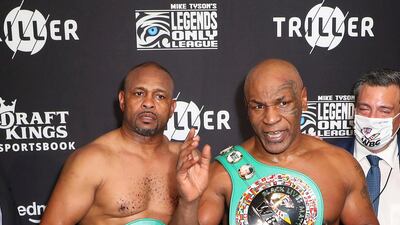 Roy Jones Jr., left, and Mike Tyson pose for photos after their exhibition boxing bout in Los Angeles. The bout was unofficially ruled a draw by the WBC judges at ringside. Triller via AP