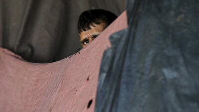 An Afghan drug addict looks out from under a bridge inhabited by drug users in Kabul, Afghanistan. Mohammad Ismail / Reuters
