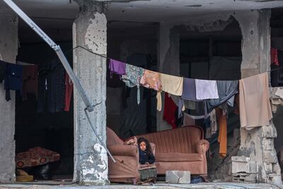 A Palestinian girl sits on a couch in a damaged apartment in Beit Lahia in the northern Gaza Strip ahead of the fast-breaking iftar meal during Ramadan. AFP