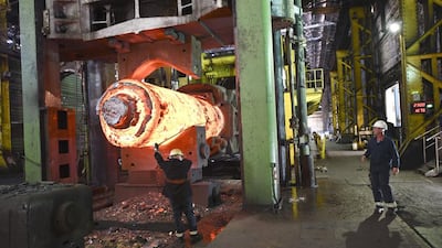 A forgeman oversees the manipulation of a 100 tonne cylinder of of freshly cast hot steel. Oli Scarff / AFP