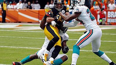 Hines Ward, No 86, of the Steelers, gets tackled by the Dolphins’ Sean Smith, No 24, on Sunday.