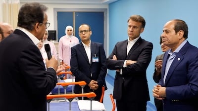 Mr Macron and Mr El Sisi listen to medical staff at the ward for Palestinian patients. AFP