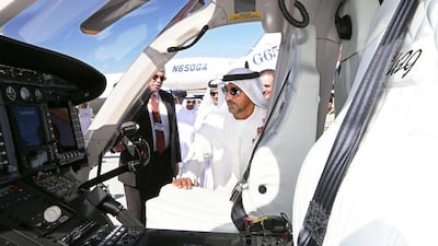 Sheikh Ahmed Bin Saeed Al Maktoum, the president of the Department of Civil Aviation, chief executive and chairman of The Emirates Group, looks at a Bell helicopter during his visit at the Middle East Business Aviation show on December 8. Pawan Singh / The National