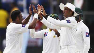 Pakistan's Abdur Rehman, left, celebrates with teammate Younis Khan, right, after taking the wicket of Sri Lanka's Kaushal Silva during the third day of their second and final Test cricket match at Colombo, Sri Lanka, on August 16, 2014. Dinuka Liyanawatte / Reuters