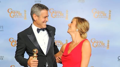Actor George Clooney poses backstage with the award for Best Actor in a Motion Picture Drama for the film "The Descendants" with Stacy Keibler. AP Photo/Mark J. Terrill