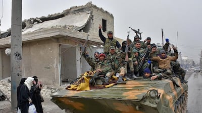 Syrian pro-government on November 30, 2016 drive their tank past civilians fleeing eastern Aleppo and gathering in Masaken Hanano, a former rebel-held district which was retaken by the regime forces last week, Regime forces and allied fighters now fully control the city's northeast and re advancing from the south-east. George Ourfalian / AFP