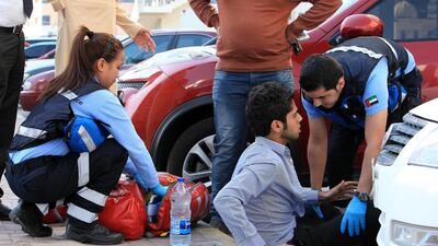 May Glicerie Book and Mohammad Rawashdeh of the National Ambulance service help a patient in Ajman. Pawan Singh / The National