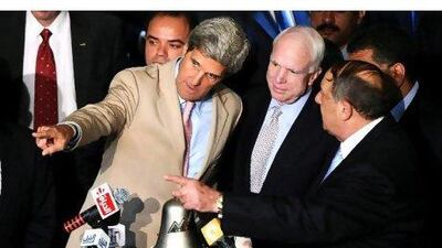 Seantor John Kerry, left, and Senator John McCain, centre, with Mohamed Abdel-Salam, chairman of the Egyptian Stock Exchange at the opening of the exchange in Cairo yesterday. Mohamed Omar / EPA