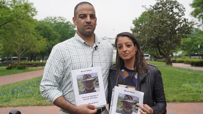 Teymoor and Tara Tahbaz display photos of their father, Morad, who is currently being held in Iran.