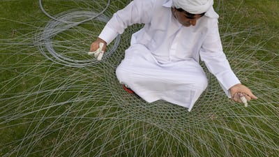 An Emirati man weaves a traditional fishing basket made from steel wire at Umm Al Quwain Museum. Antonie Robertson / The National