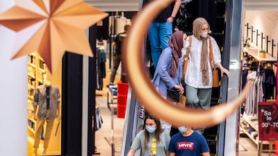 Shoppers walk under ceiling decorations at Al Wahda Mall. Victor Besa / The National