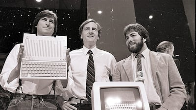 In this April 24, 1984, file photo, from left, Steve Jobs, chairman of Apple Computers, John Sculley, president and CEO, and Steve Wozniak, co-founder of Apple, unveil the new Apple IIc computer in San Francisco. Apple on Wednesday, Oct. 5, 2011 said Job???