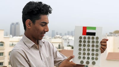 Nihad Hassan with his Emirates coin collection. Chris Whiteoak / The National