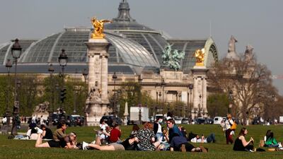 People enjoy warm weather near the Invalides in Paris. Reuters