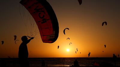 Kitesurfers practice at sunset off the coast of Tel Aviv in Israel. AFP
