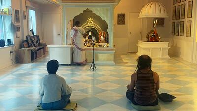 Priest Prakash, centre, livestreams prayer ceremonies every week. AP