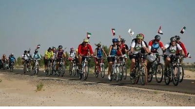 At the end of their odyssey, riders in Gulf for Good's Cycle the Seven Emirates challenge head to the finish line with UAE flags flying. Courtesy of G4G Communications